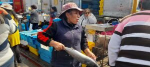 Debido a la masiva presencia de personas en el Terminal Pesquero, comerciantes salieron de sus puestos para atraer a la gente a comprar en su puesto. (Foto: Kelly Luna | Iletrados Noticias). 